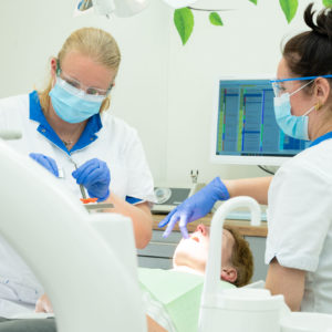 twee tandartsen behandelen patiënt met tand- of kiespijn